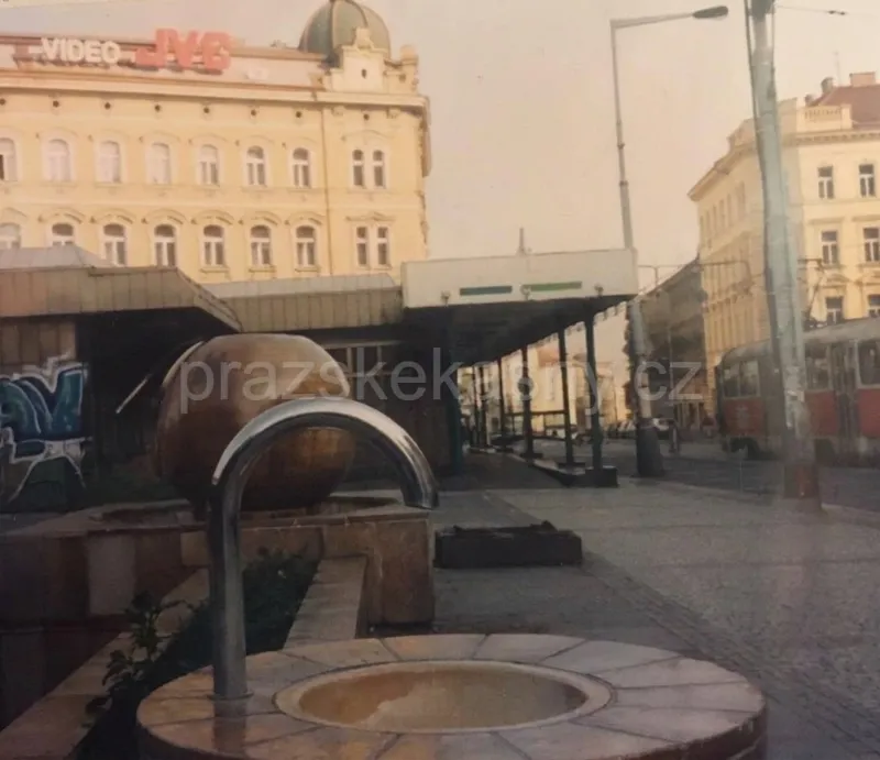 Fotografie od neznámého autora, editací v postprodukci odstraněna žena, která seděla před pítkem. Zakončení kovové trubky tak nemusí být přesné.